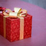 Elegant red gift box with gold ribbon, perfect for Christmas celebrations and holiday gifting.